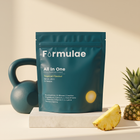 Formulae Booty Booster tropical pouch on a cream studio backdrop with a teal kettlebell and fresh pineapple