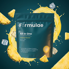 Formulae Booty Booster pouch on deep teal with a bright yellow pineapple drink splash, flying pineapple wedges and ice